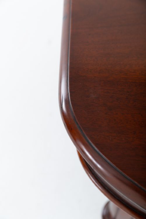 A Victorian mahogany extending dining table with two removable extension leaves, turned fluted legs, and brass castors. View IV