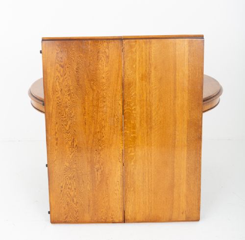 A Victorian blonde oak extending dining table featuring turned fluted legs supported on metal castors. View VIII