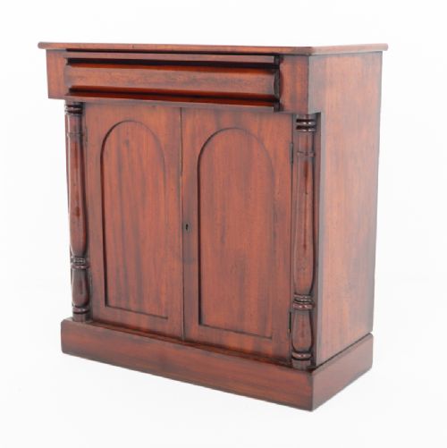 A Victorian mahogany side cabinet featuring two arched panel doors, turned side columns, a top frieze drawer, and a solid plinth base. View V