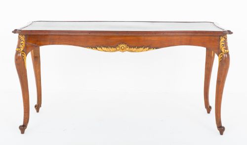 fig 1. A mahogany centre writing table with cabriole legs, gilded rococo mounts on the frieze and knees, and a dark green leather inset surface.