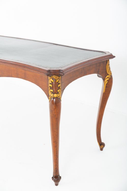 A mahogany centre writing table with cabriole legs, gilded rococo mounts on the frieze and knees, and a dark green leather inset surface. View III
