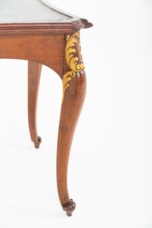 A mahogany centre writing table with cabriole legs, gilded rococo mounts on the frieze and knees, and a dark green leather inset surface. View VI
