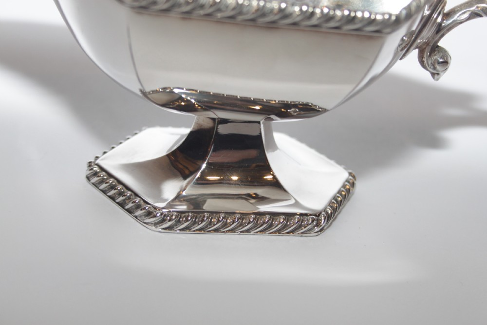 A pair of silver plated sauce boats with pedestal bases, scroll handles, and rope twist borders. View V