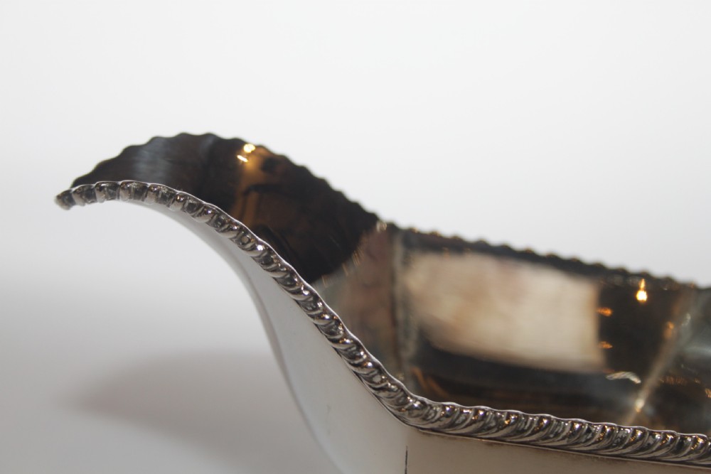 A pair of silver plated sauce boats with pedestal bases, scroll handles, and rope twist borders. View VII