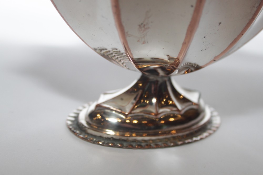 A silver-plated pedestal bon bon dish featuring a scalloped rim, a swing handle, and a cobalt blue glass insert. View VI