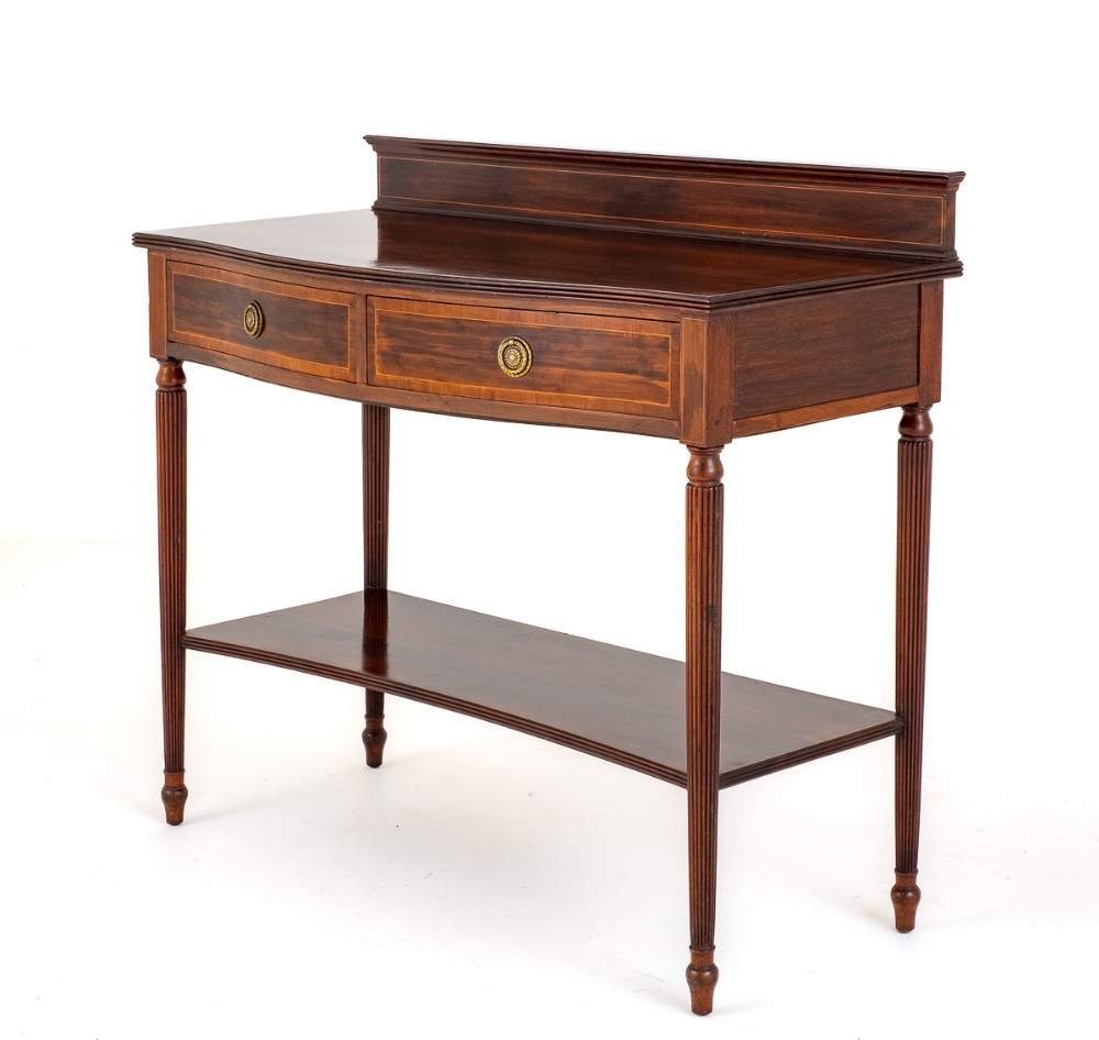 An inlaid mahogany server featuring two frieze drawers with circular brass drop handles, reeded legs, a lower tier shelf, and a low rear gallery.