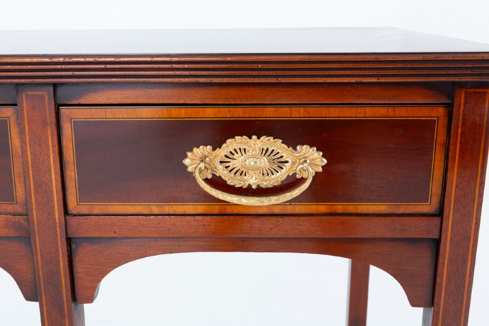 A Sheraton Revival mahogany server featuring three drawers with brass handles, decorative string inlay, arched spandrels, and four slender tapered legs. View V
