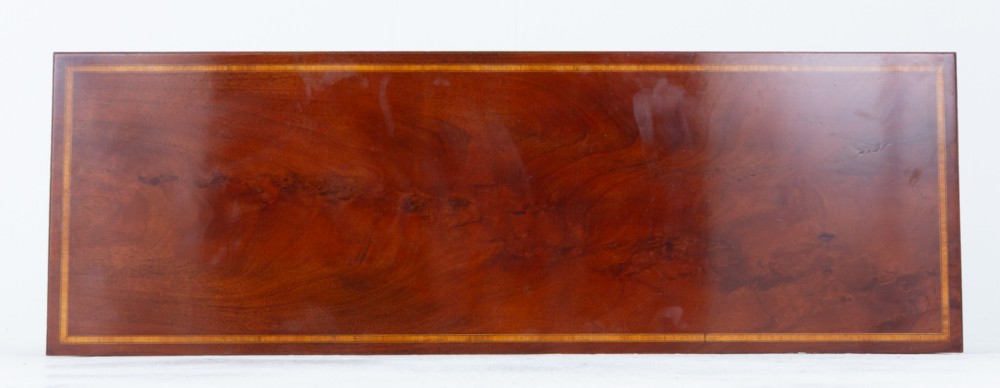 A Sheraton Revival mahogany server featuring three drawers with brass handles, decorative string inlay, arched spandrels, and four slender tapered legs. View VI