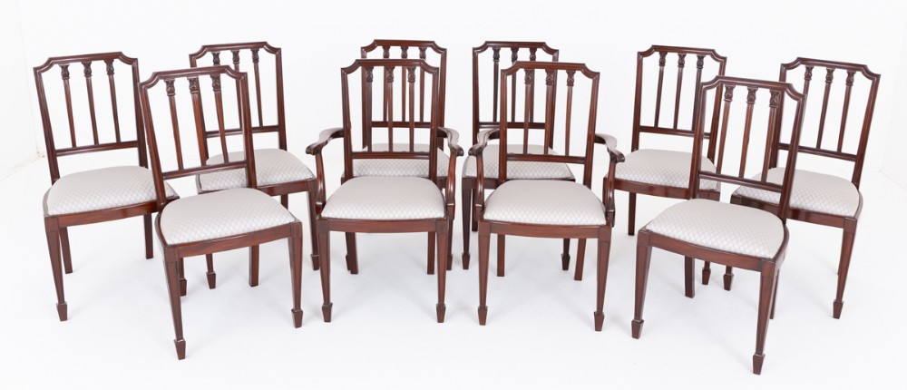 A set of ten mahogany dining chairs featuring vertical splat backs, tapered legs with spade feet, and neutral patterned upholstered seats.