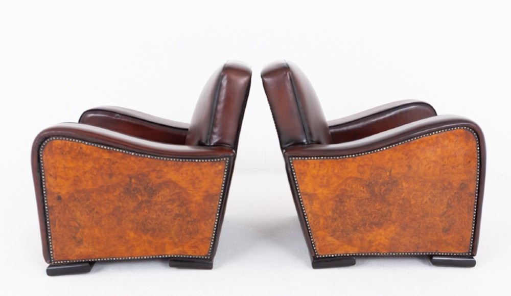 A pair of Art Deco club chairs upholstered in brown leather with burr walnut side panels and studded trim. View IV