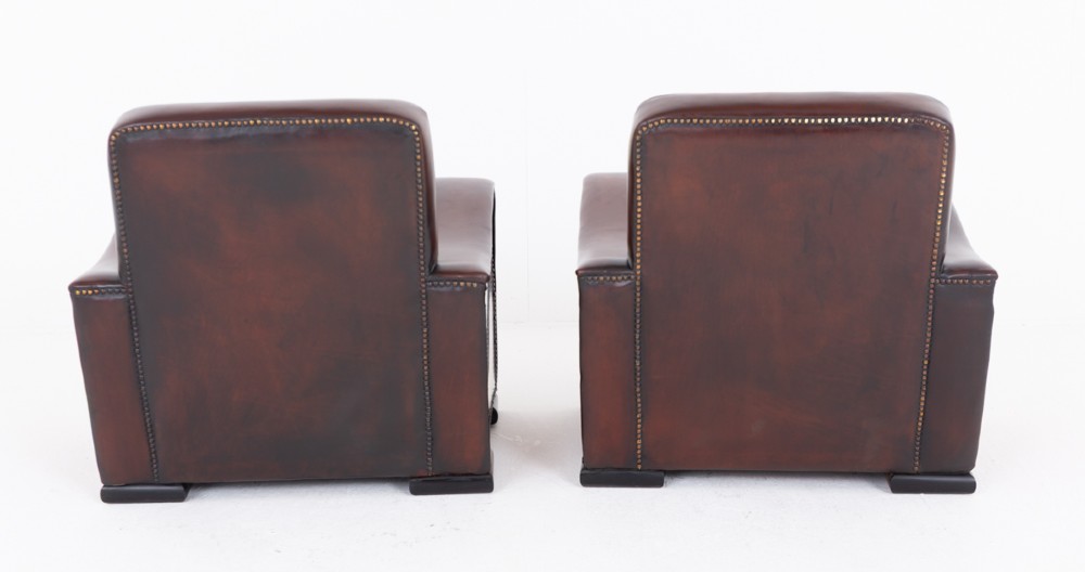 A pair of Art Deco club chairs upholstered in brown leather with burr walnut side panels and studded trim. View V