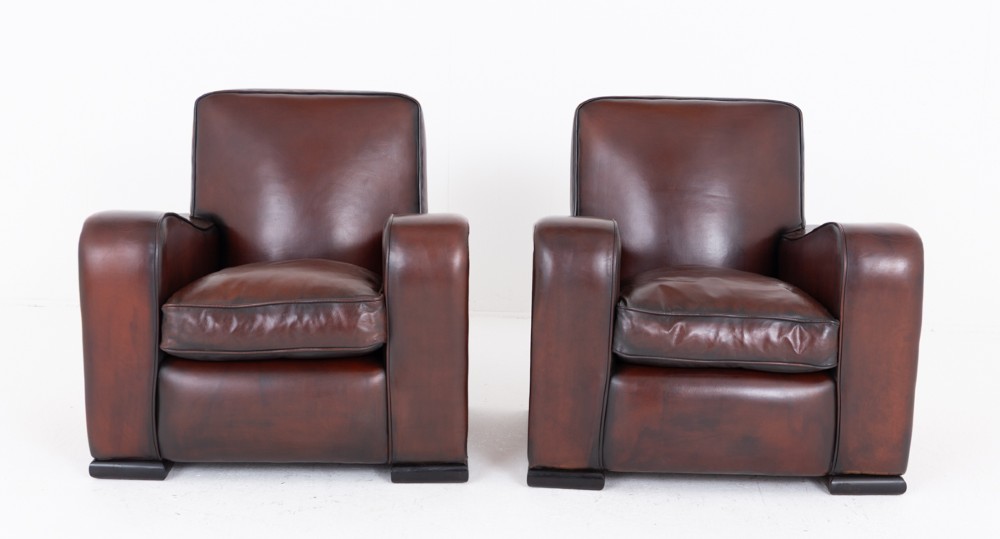 A pair of Art Deco club chairs upholstered in brown leather with burr walnut side panels and studded trim. View VII