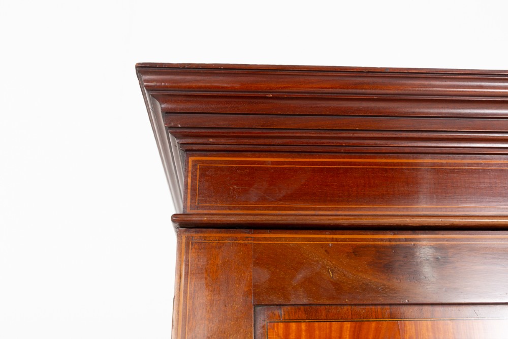 A tall Sheraton Revival mahogany two-door wardrobe featuring inlaid panelled doors, a lower base drawer, and bracket feet. View VII