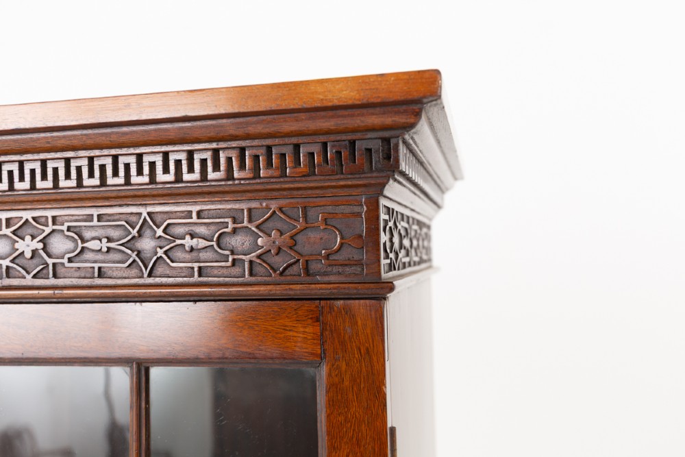 A mahogany Chippendale style glazed bookcase featuring geometric glass door panels, a carved frieze, and cabriole legs ending in ball and claw feet. View IV