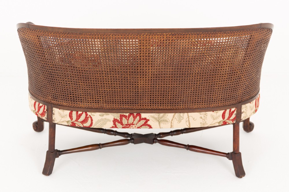 A three-piece Carolean style seating suite comprising a settee and two matching armchairs with woven cane backrests, carved scroll stretchers, and floral fabric seat cushions. View IX