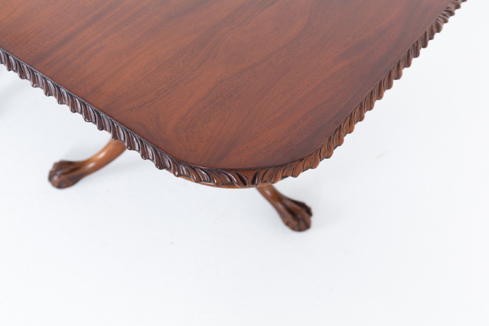 A Regency Revival twin-pedestal mahogany dining table featuring carved edging, turned support pillars, and splayed legs ending in carved feet. View III
