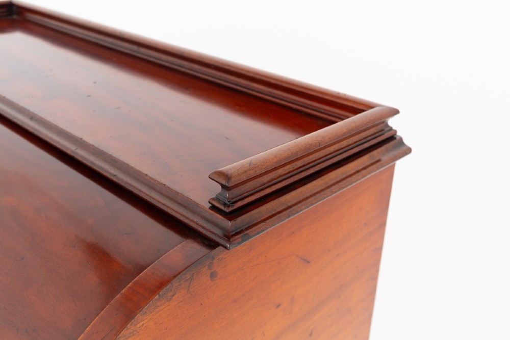 A Victorian mahogany cylinder desk featuring a curved roll-top hood, multiple pedestal drawers, and turned wooden knobs. View VIII