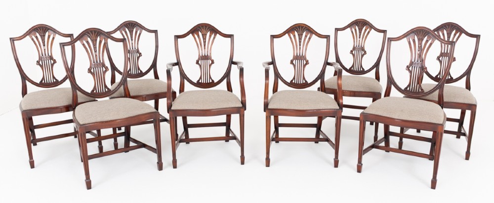 A set of eight mahogany shield back dining chairs comprising six side chairs and two carvers with neutral beige fabric seats. View II