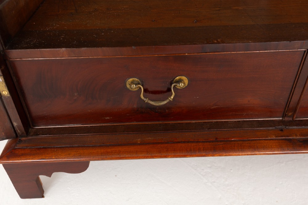 A Georgian mahogany side cabinet featuring two cupboard doors with shaped panel mouldings, brass escutcheons, and bracket feet. View IV