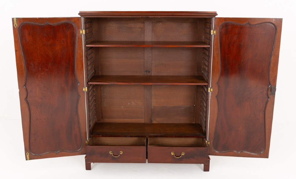 A Georgian mahogany side cabinet featuring two cupboard doors with shaped panel mouldings, brass escutcheons, and bracket feet. View V