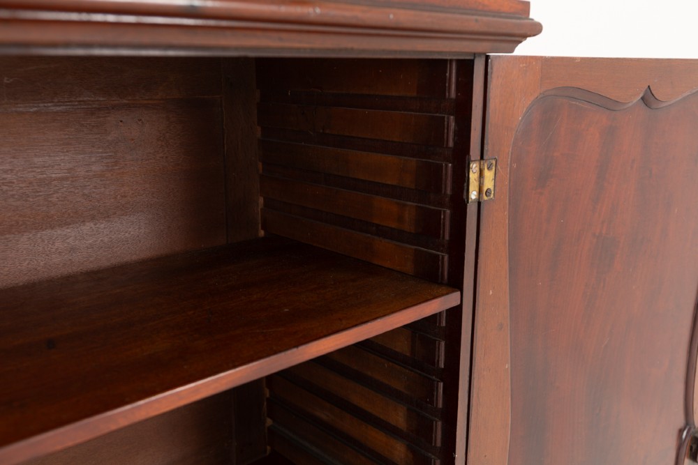 A Georgian mahogany side cabinet featuring two cupboard doors with shaped panel mouldings, brass escutcheons, and bracket feet. View VI