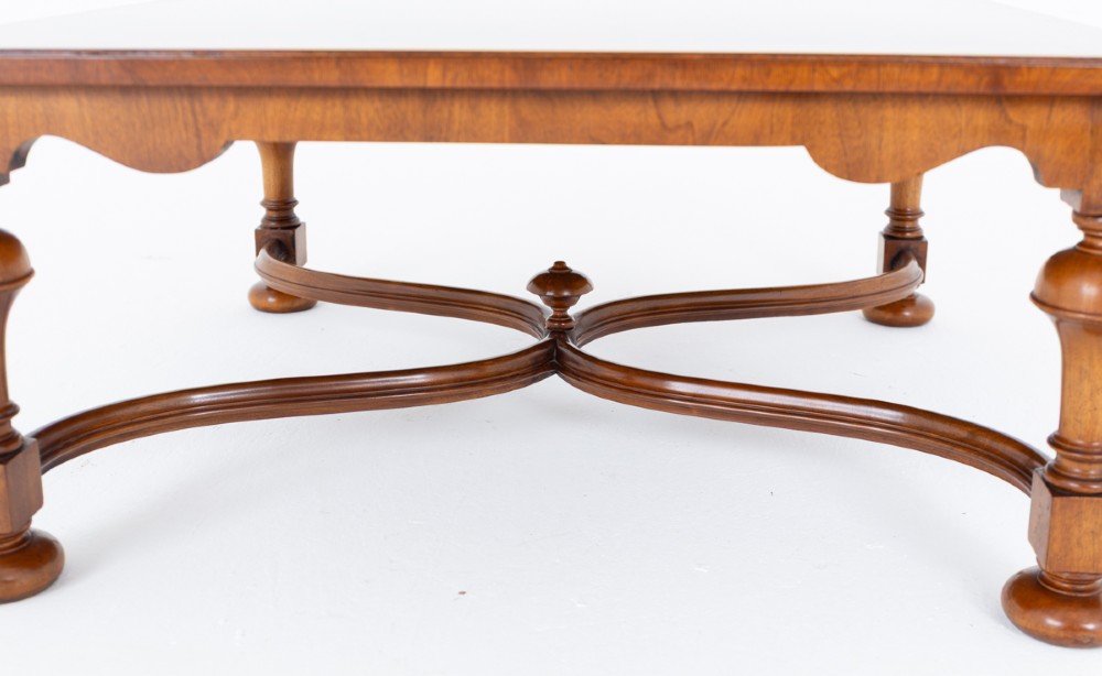 A square walnut coffee table featuring a figured burr walnut top, turned baluster legs, and a curved X-stretcher base. View III