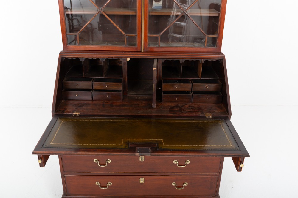A Georgian mahogany bureau bookcase featuring an upper cabinet with astragal glazed doors, a slant-front writing slope, four graduated drawers, and bracket feet. View V