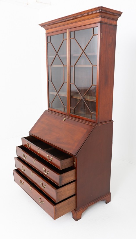 A Georgian mahogany bureau bookcase featuring an upper cabinet with astragal glazed doors, a slant-front writing slope, four graduated drawers, and bracket feet. View VIII