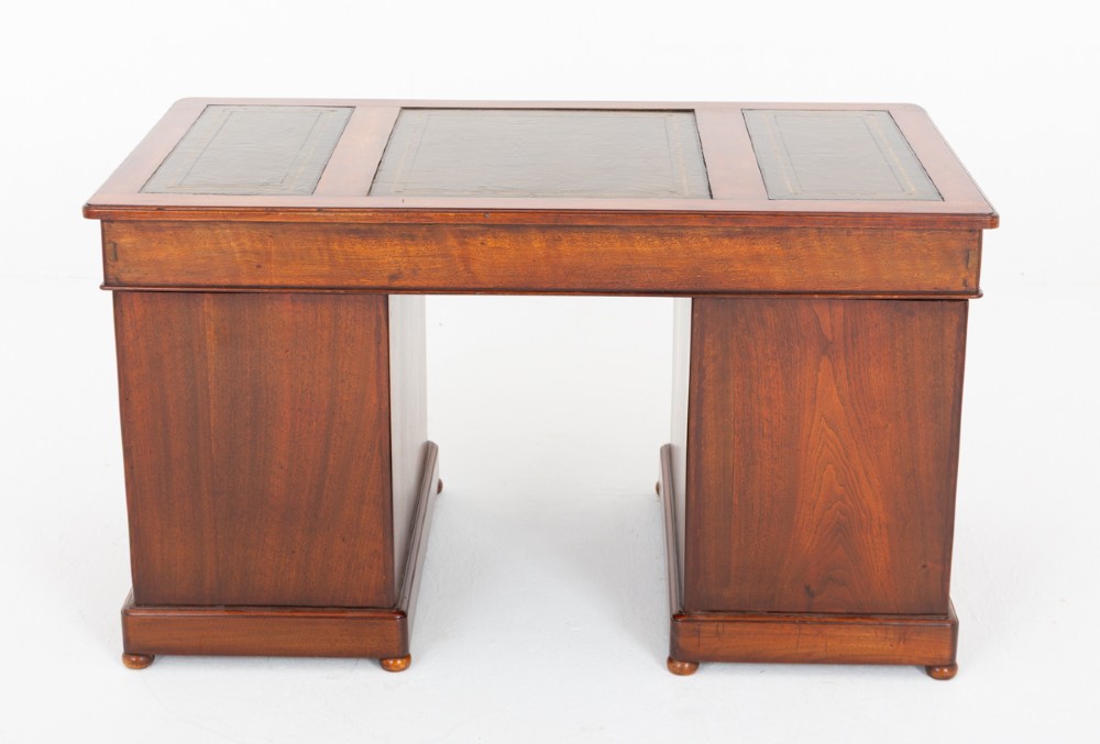 A Victorian mahogany pedestal desk featuring a green leather inset writing surface, multiple drawers with brass handles, and a plinth base. View VIII