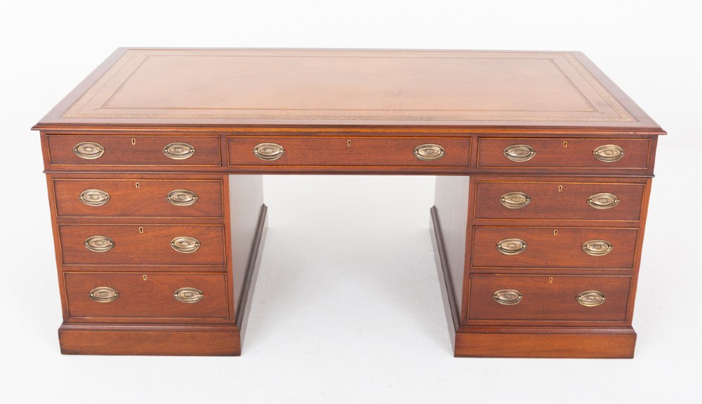 A Georgian style mahogany partners desk featuring a tan leather writing surface, multiple drawers with oval brass handles, and twin pedestal supports. View II