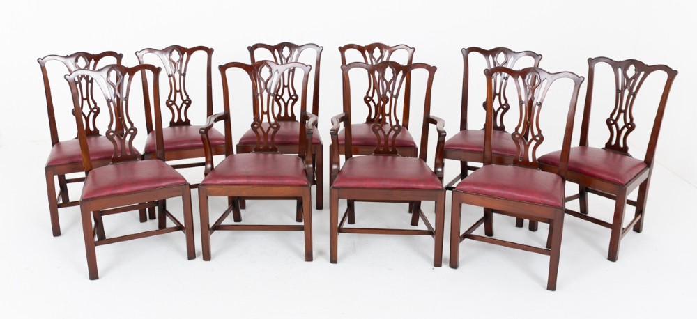 A set of ten mahogany Chippendale style dining chairs with carved pierced back splats and red upholstered seats.