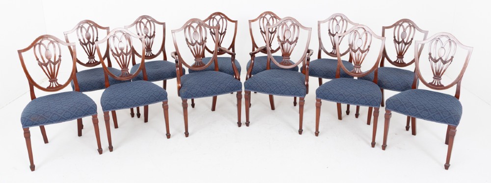 A set of twelve mahogany Hepplewhite style dining chairs with shield backs, carved urn splats, and blue patterned upholstered seats. View II