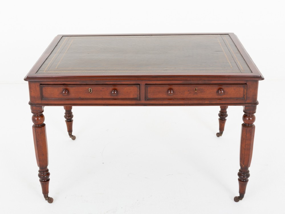 A Victorian mahogany partners writing table featuring a green leather inset top, turned legs on brass castors, and drawers with wooden knob handles. View II