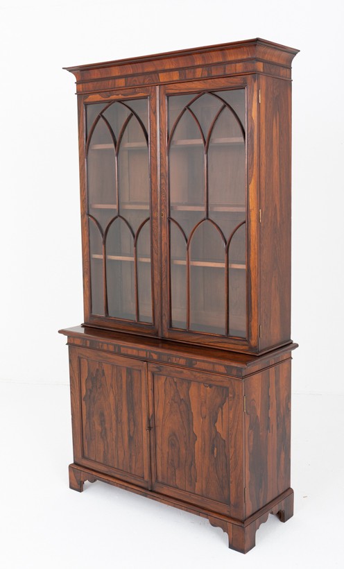 A William IV rosewood glazed bookcase featuring Gothic arched glazing bars on the upper double doors above a two-door solid cabinet base. View VIII