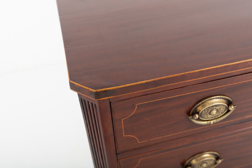 A Regency mahogany chest of four graduated drawers featuring brass oval backplate handles, reeded side pilasters, and splayed bracket feet. View III