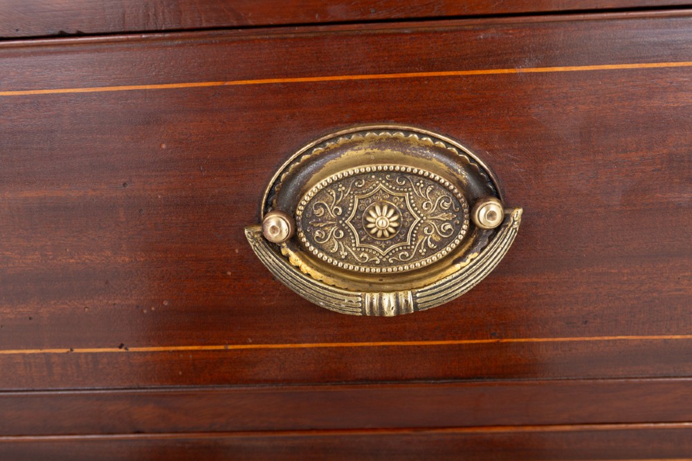 A Regency mahogany chest of four graduated drawers featuring brass oval backplate handles, reeded side pilasters, and splayed bracket feet. View VI
