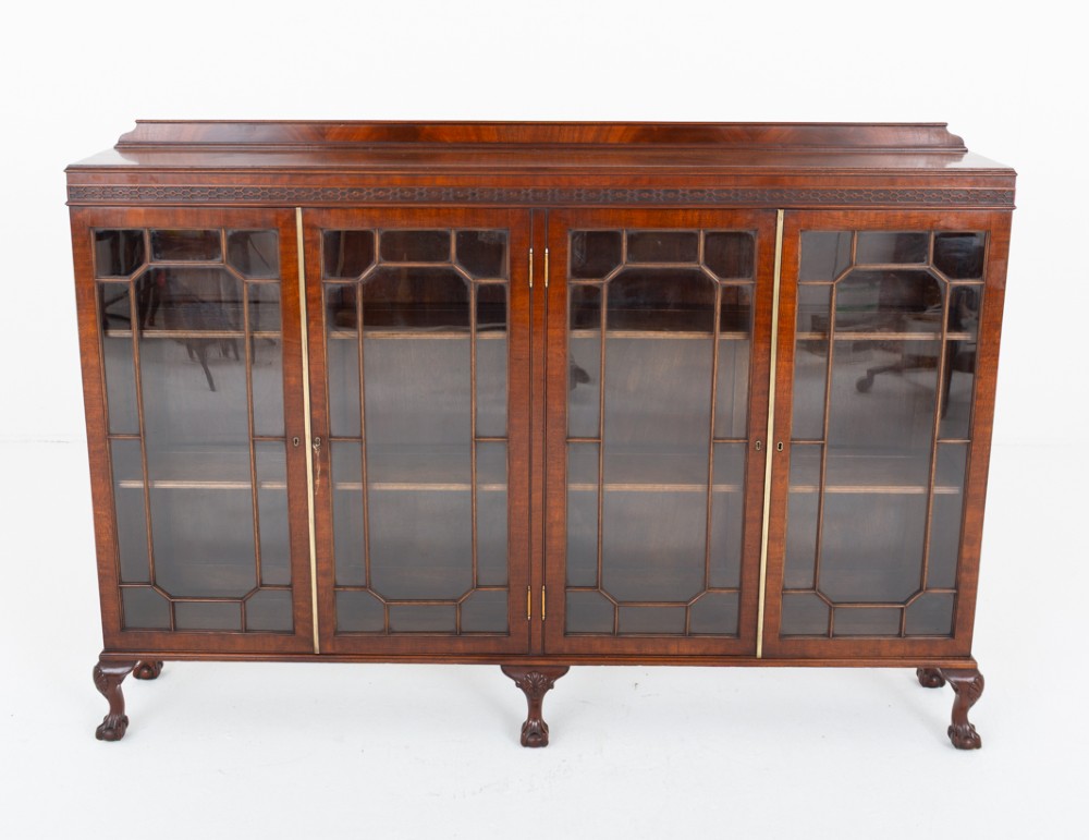 A low mahogany four-door side cabinet featuring geometric astragal glazed glass panels and carved claw and ball feet. View II