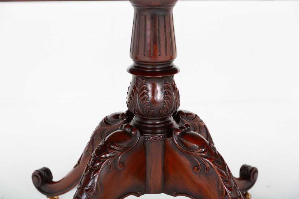 A large Regency style dark mahogany dining table featuring a three-pedestal base with carved splayed legs resting on brass castors. View VI