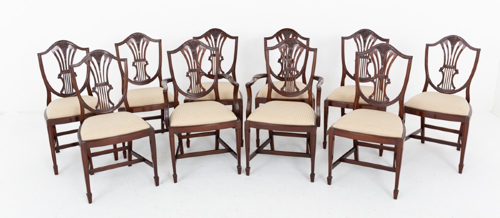 A set of ten mahogany Hepplewhite style dining chairs with shield backs and cream patterned upholstered seats. View II