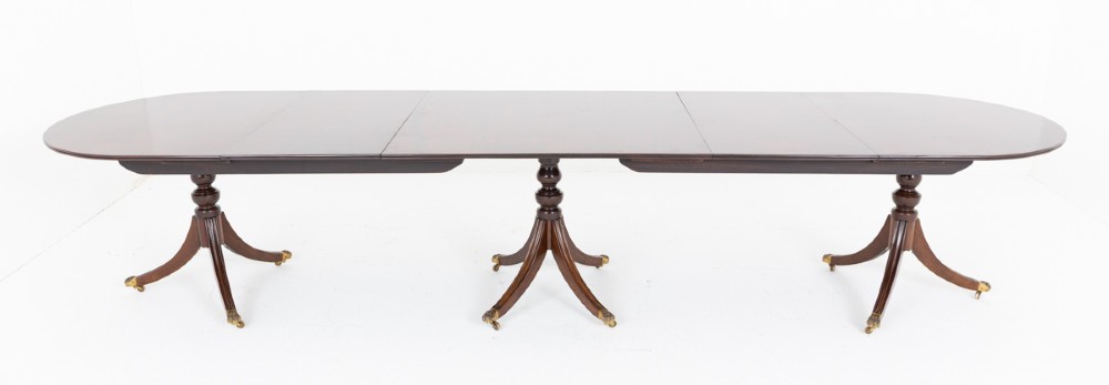 A large Regency Revival dark mahogany three-pedestal dining table with reeded splayed legs and brass claw castors. View IX