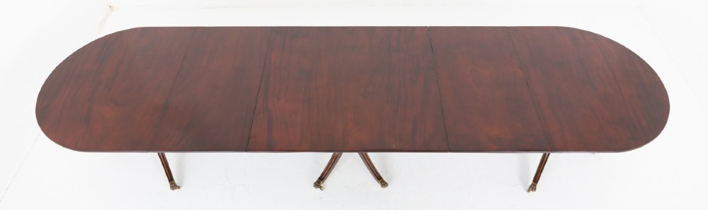 A large Regency Revival dark mahogany three-pedestal dining table with reeded splayed legs and brass claw castors. View XI