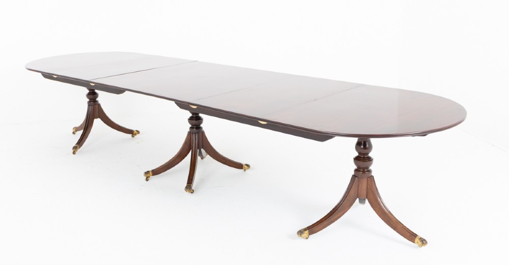 A large Regency Revival dark mahogany three-pedestal dining table with reeded splayed legs and brass claw castors. View XIII