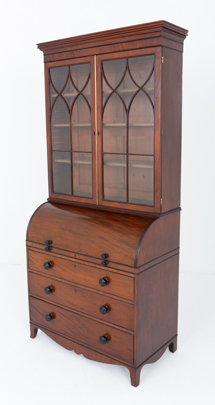 A Regency mahogany cylinder bureau bookcase featuring Gothic astragal glazed upper doors above a curved roll-top desk and three long drawers with turned dark handles. View XI