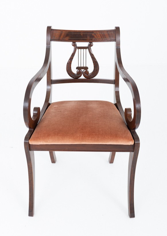 A set of ten mahogany Regency style dining chairs featuring carved lyre back splats, curved armrests on two carvers, and rust-coloured upholstered seats. View III