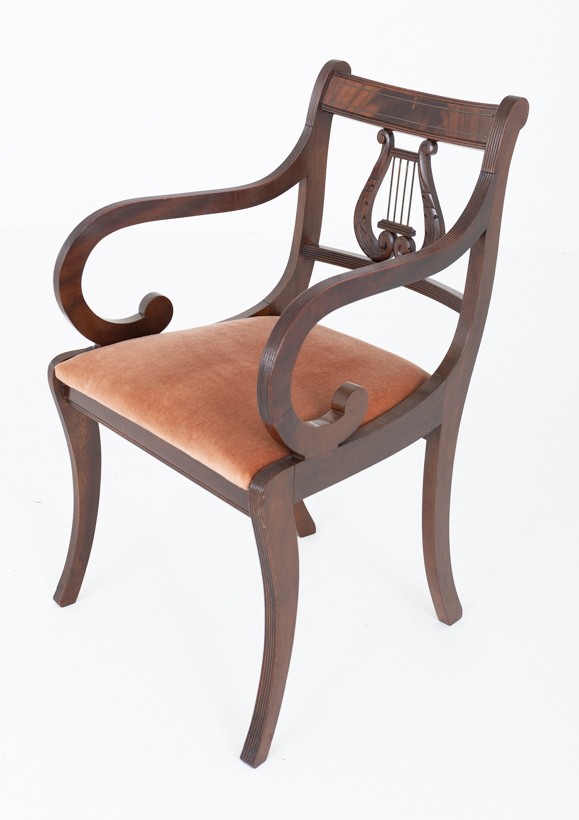 A set of ten mahogany Regency style dining chairs featuring carved lyre back splats, curved armrests on two carvers, and rust-coloured upholstered seats. View V