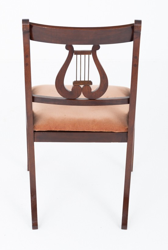 A set of ten mahogany Regency style dining chairs featuring carved lyre back splats, curved armrests on two carvers, and rust-coloured upholstered seats. View VII
