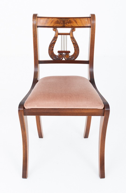 A set of ten mahogany Regency style dining chairs featuring carved lyre back splats, curved armrests on two carvers, and rust-coloured upholstered seats. View VIII