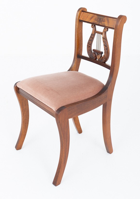 A set of ten mahogany Regency style dining chairs featuring carved lyre back splats, curved armrests on two carvers, and rust-coloured upholstered seats. View X