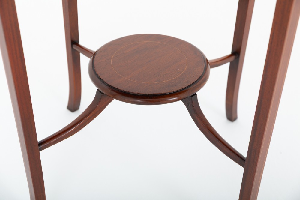 A circular mahogany occasional table featuring four flared legs joined by a central lower circular tier. View II