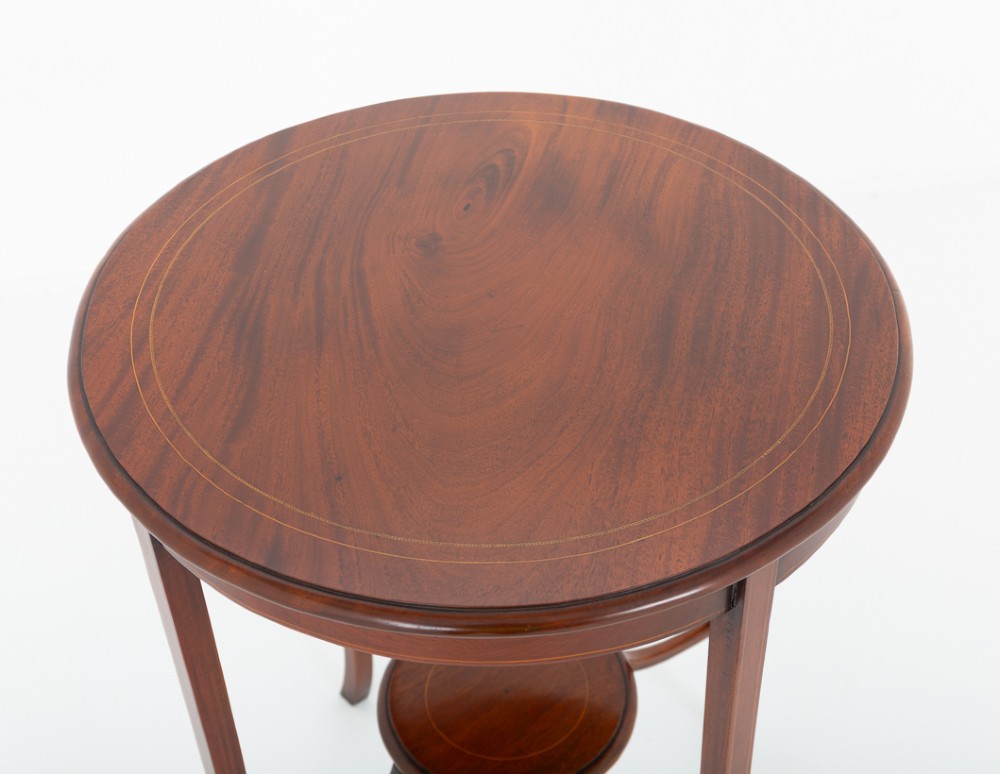 A circular mahogany occasional table featuring four flared legs joined by a central lower circular tier. View III